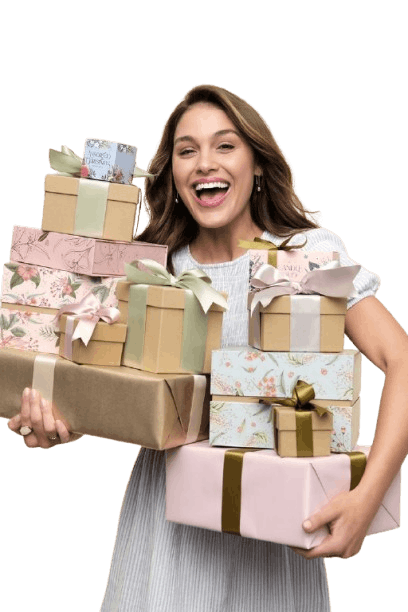 Smiling woman holding multiple pastel gift boxes wrapped with decorative ribbons and bows against a soft beige background